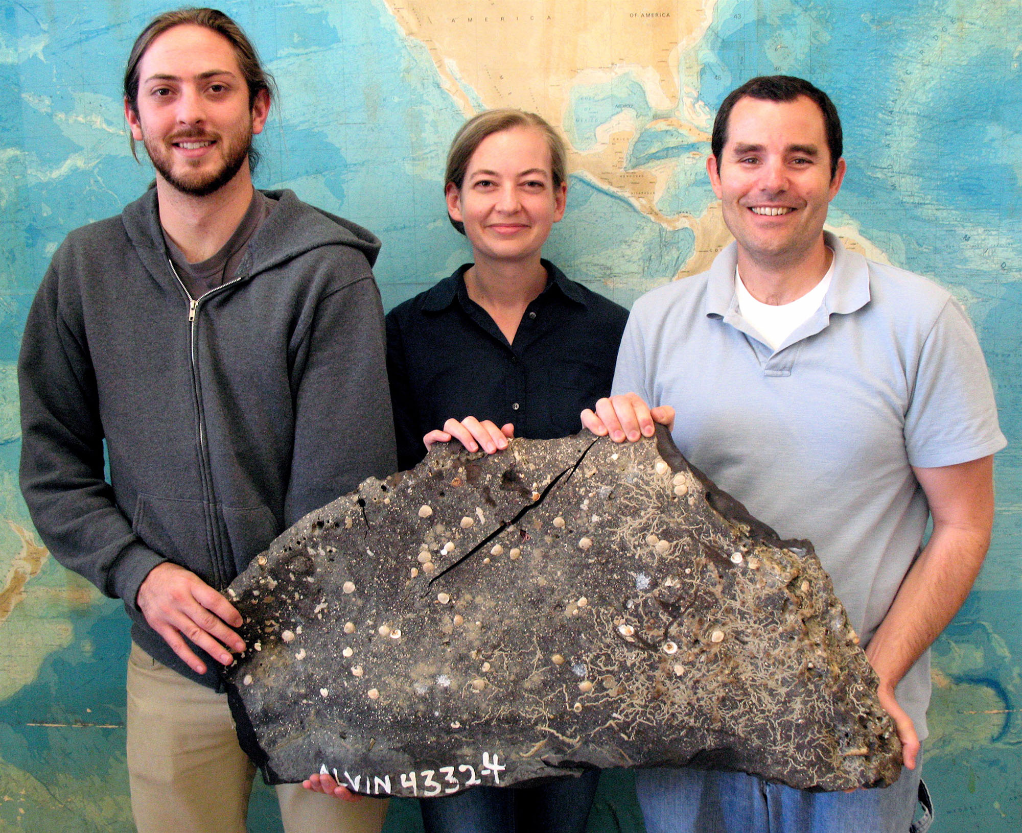 UCSB scientists holding a large piece of asphalt from SB Channel