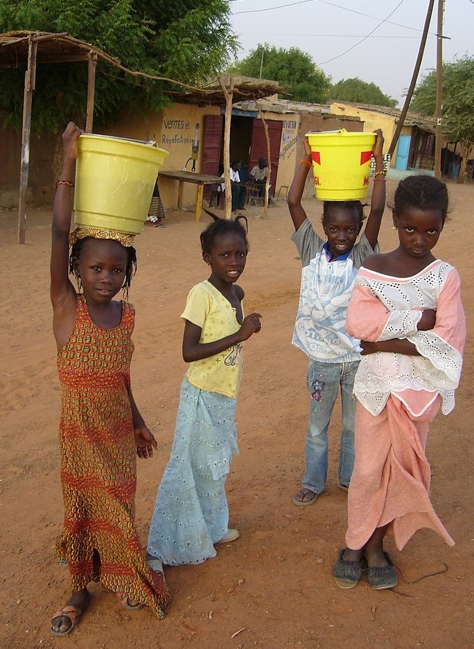 girls carrying buckets of water