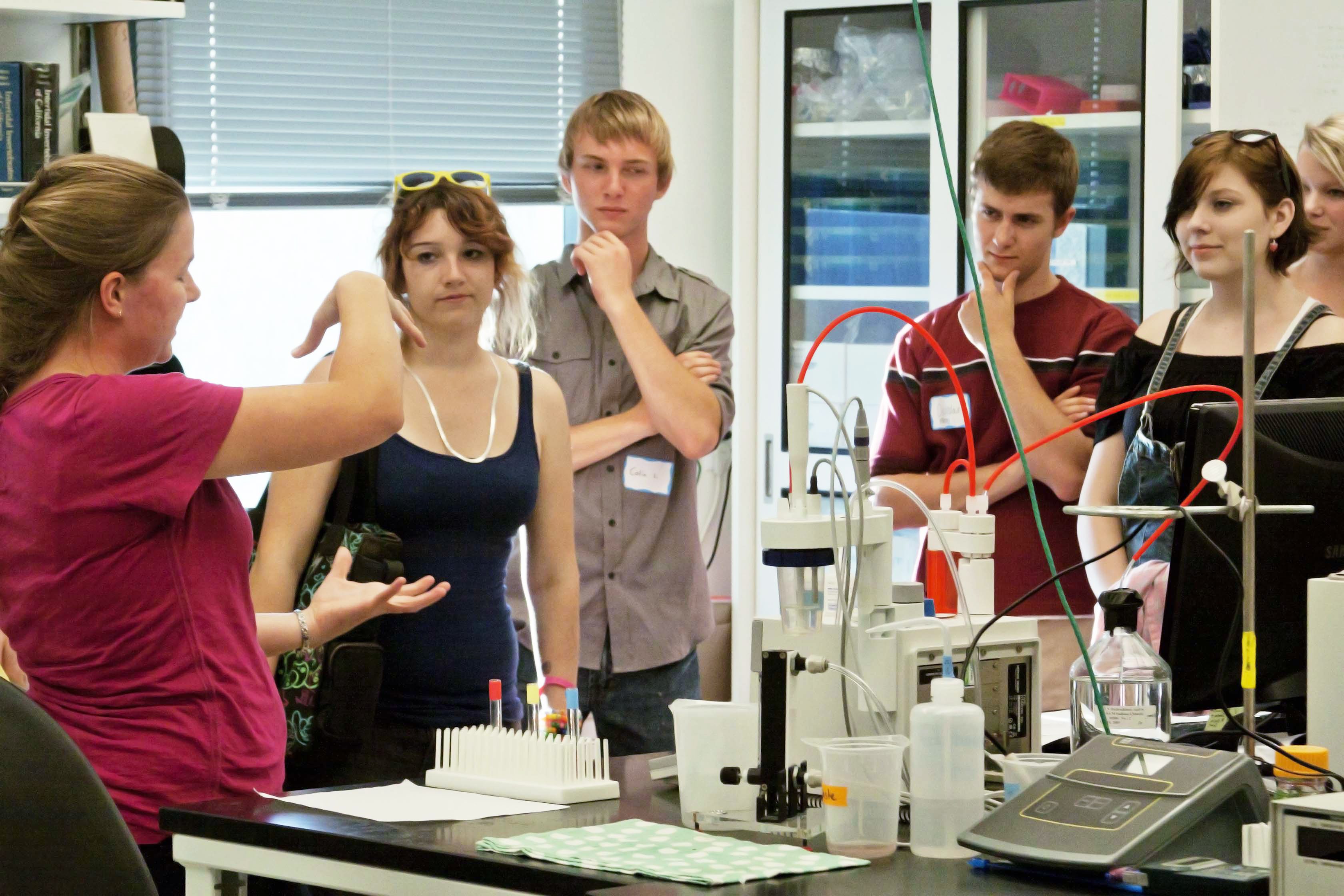 High school students listen to undergraduate in Hofmann lab