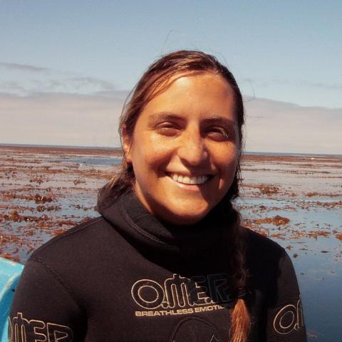 Portrait of Anita Giraldo-Ospina wearing a wetsuit with beach in background