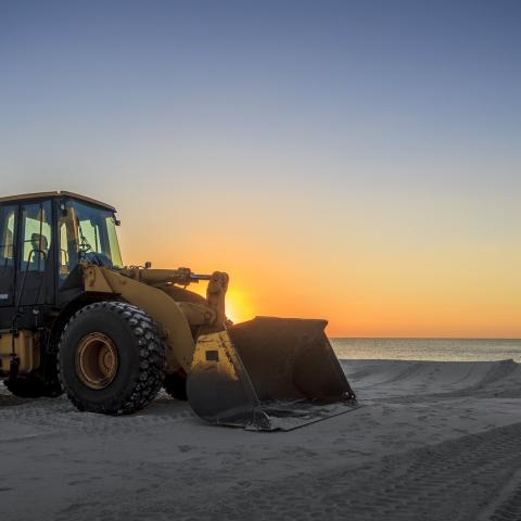 loader tractor cleaning a beach