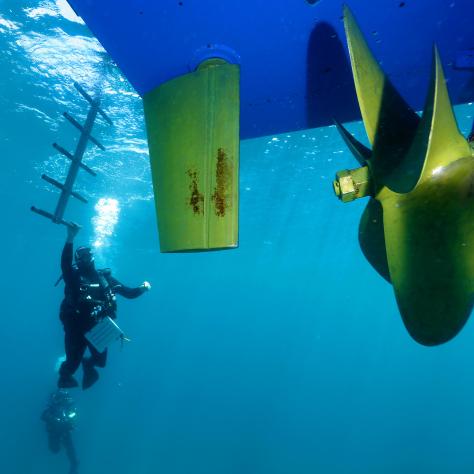 Diver close to the propeller of big boat 