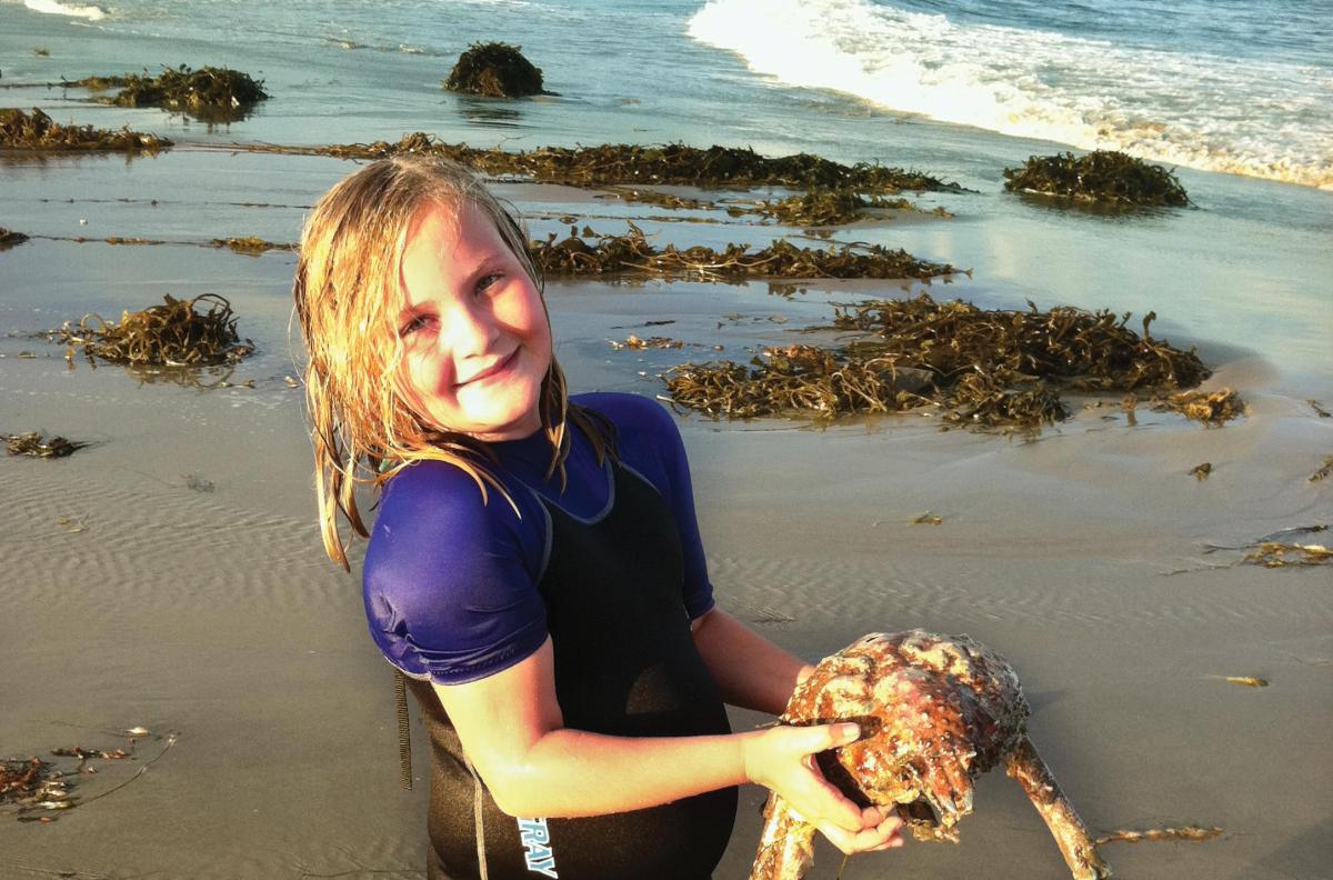 Grade school girl holds a big crab at The REEF beach