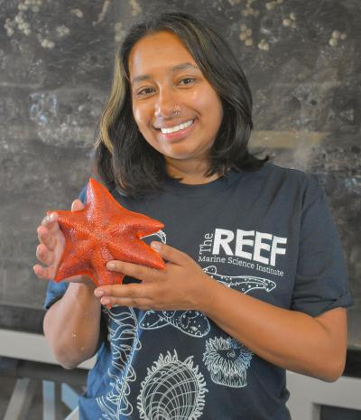 Mehran Sajjad holds a sea star at The REEF
