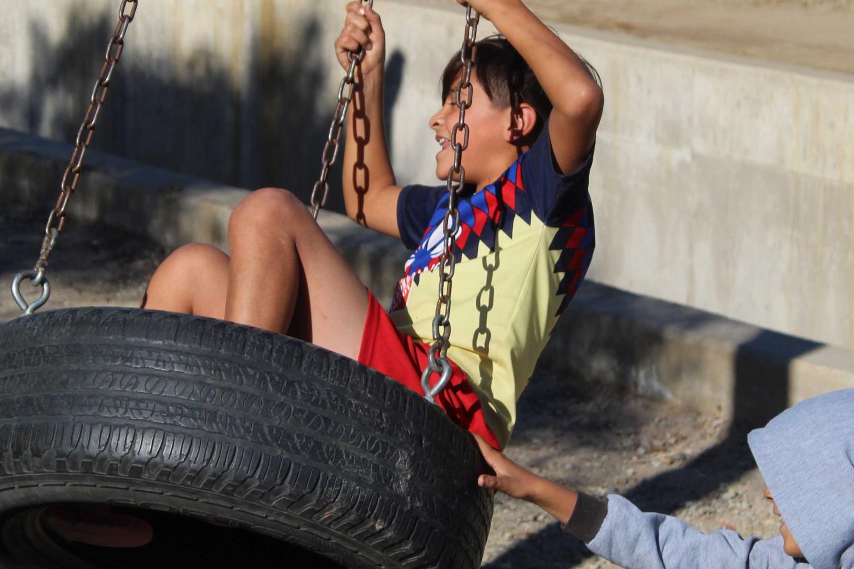 Child swinging on tire swing