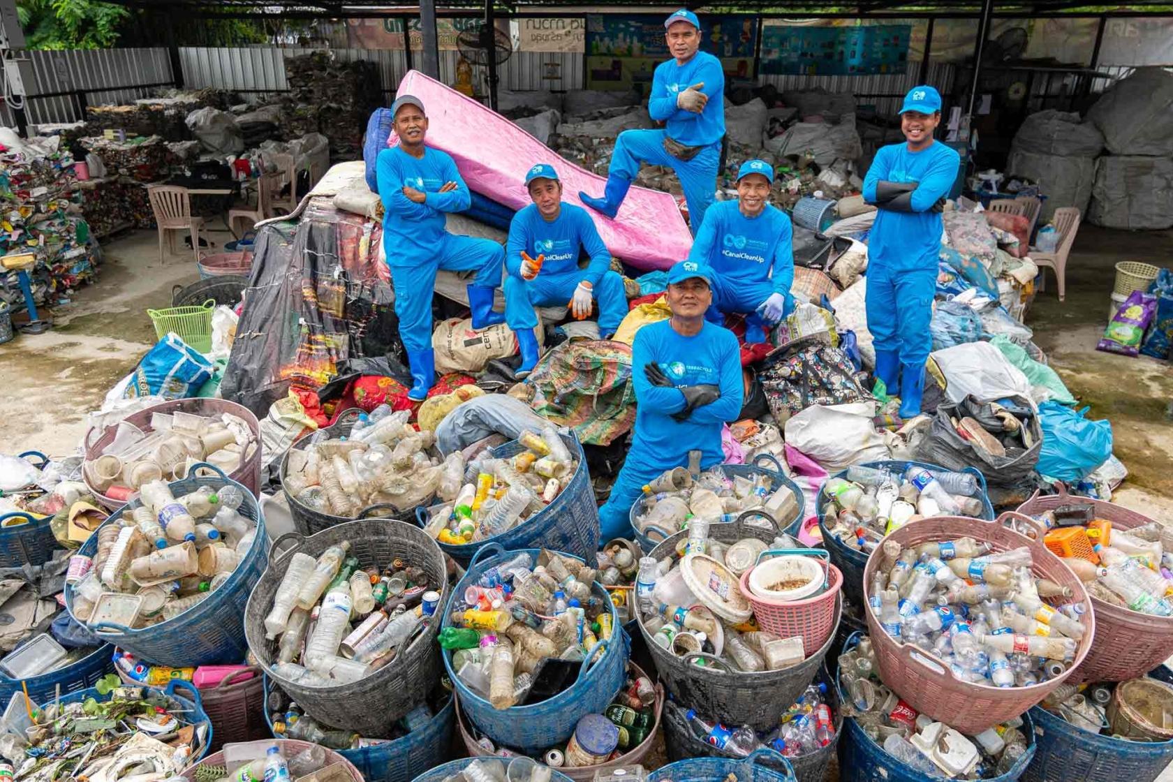 TerraCycle Global Foundation team pose standing on pile of plastic trash